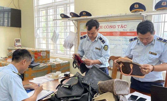 Đội Quản lý thị trường số 1 kiểm tra số hàng giả mạo nhãn hiệu. Ảnh Hồng Phương.